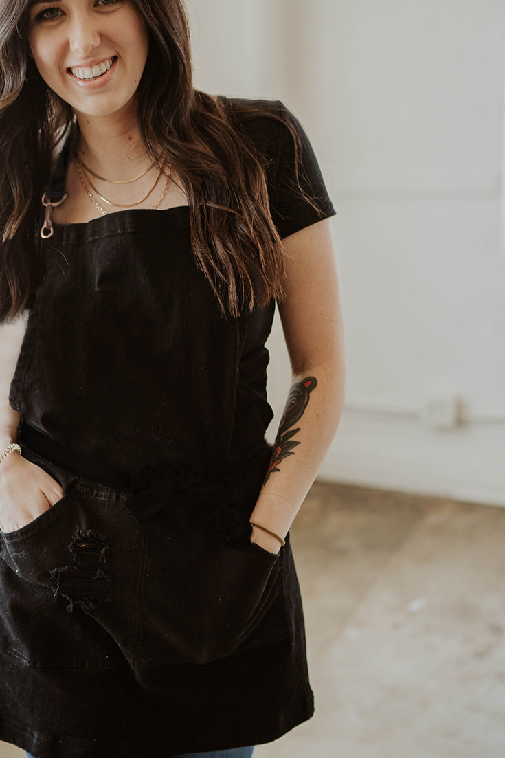 Pure black distressed denim apron by J Clark Designed worn by female model