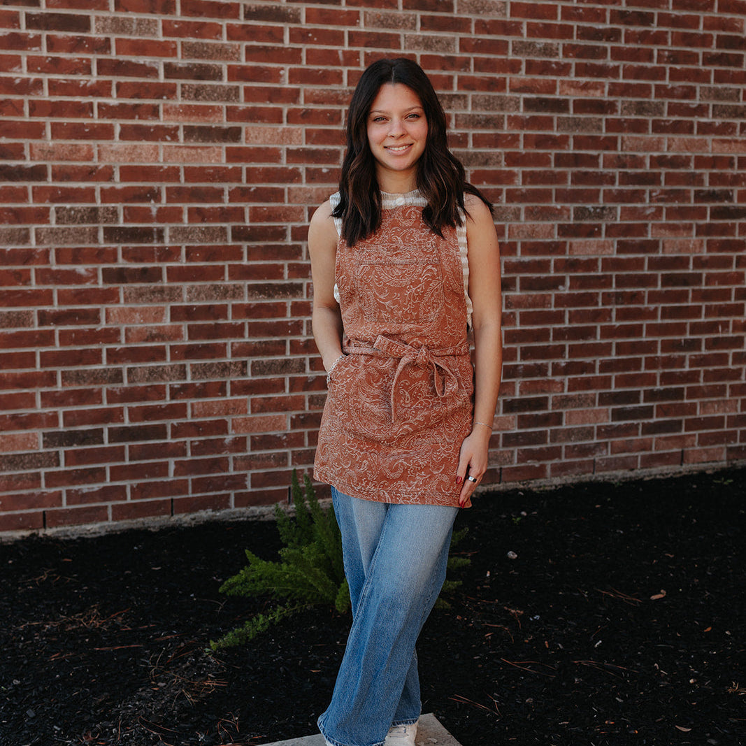 The Bohemian paisley cross-back denim salon apron by J Clark Designed front view on model