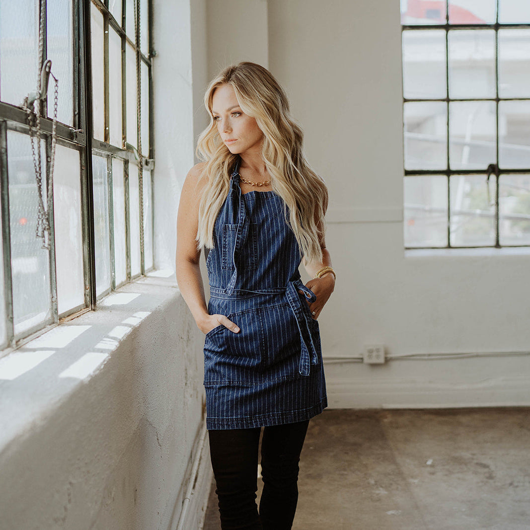 Stylist wearing navy pinstripe apron